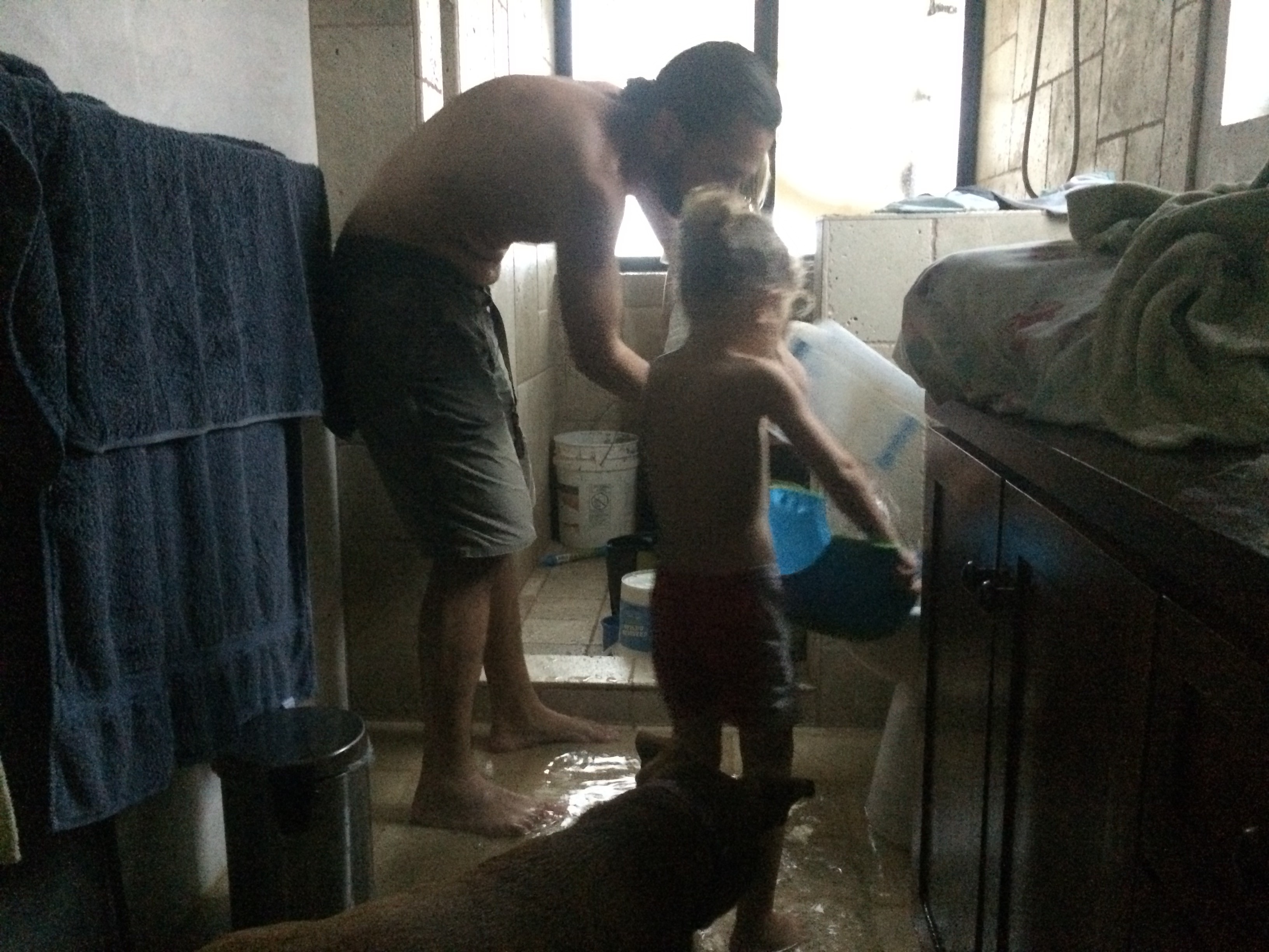 My husband and daughter scoop water from the floor and pour it down the toilet, where the storm’s pressure sucked it away.